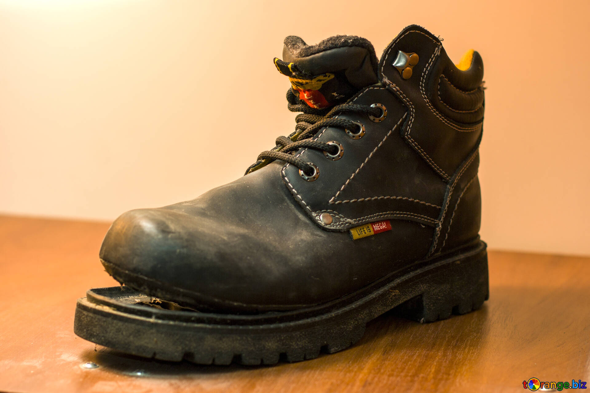 A leather work boot where the sole is separating from the upper.